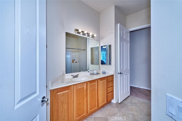 full bath featuring vanity and baseboards