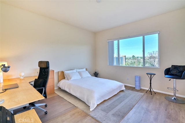 bedroom with baseboards and wood finished floors