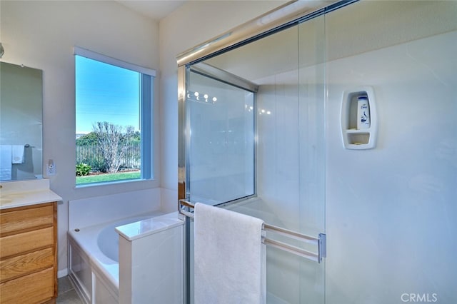 bathroom featuring a bath, a stall shower, and vanity