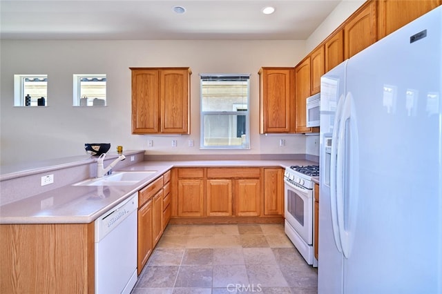 kitchen with recessed lighting, white appliances, a sink, light countertops, and brown cabinets