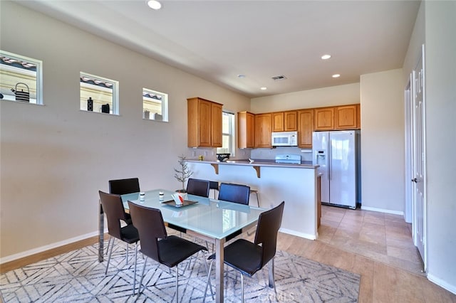 dining space featuring light wood-type flooring, recessed lighting, visible vents, and baseboards