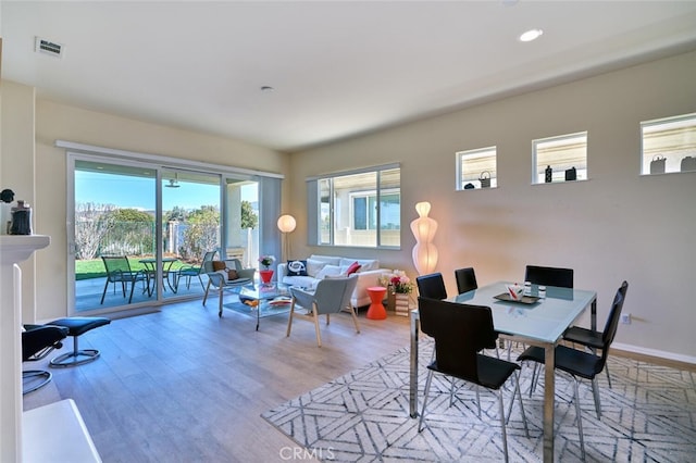 dining area with baseboards, wood finished floors, visible vents, and recessed lighting