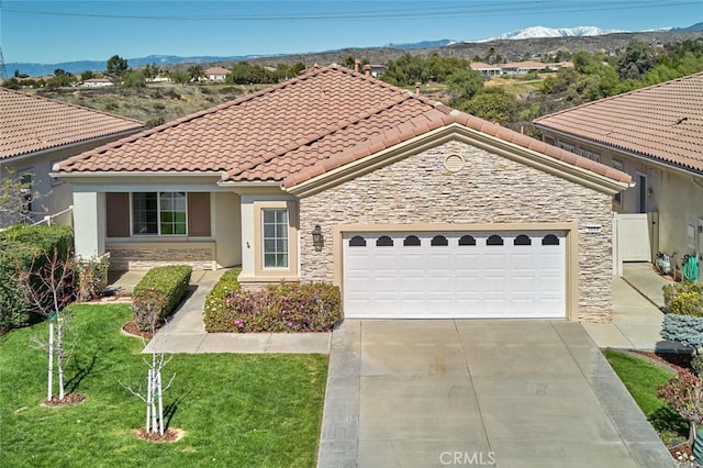 mediterranean / spanish house with stucco siding, a garage, stone siding, driveway, and a tiled roof