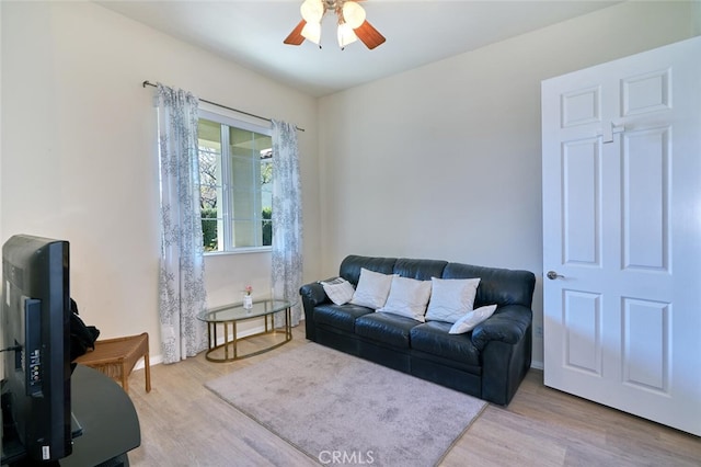 living room featuring a ceiling fan and wood finished floors