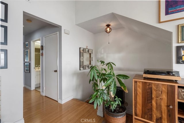 corridor featuring baseboards and wood finished floors