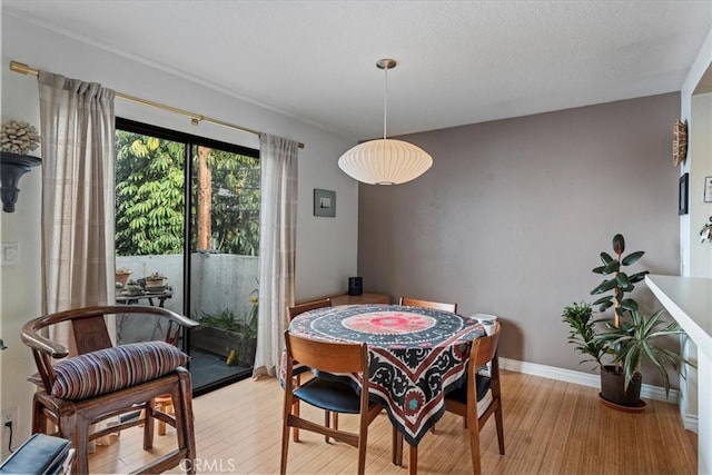 dining space with baseboards and light wood finished floors