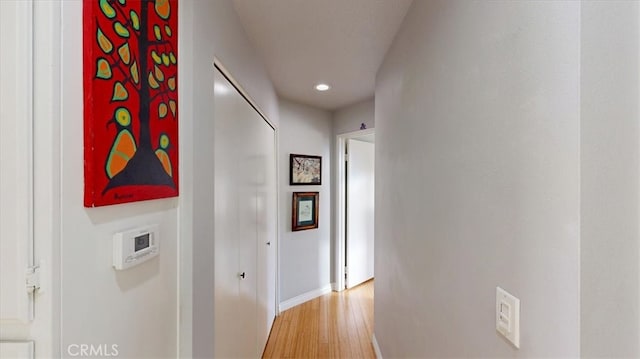 corridor featuring baseboards and light wood-type flooring