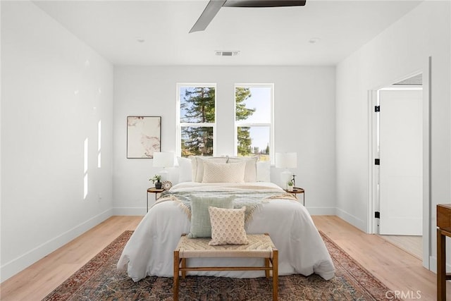 bedroom featuring light wood-type flooring, visible vents, and baseboards