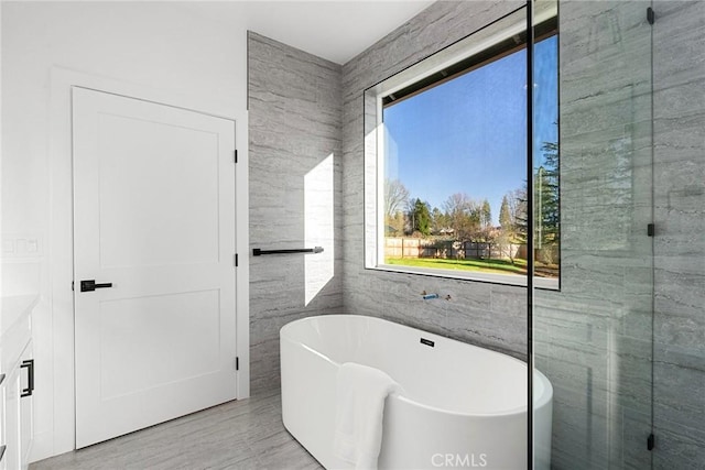 bathroom featuring a freestanding bath and tile walls