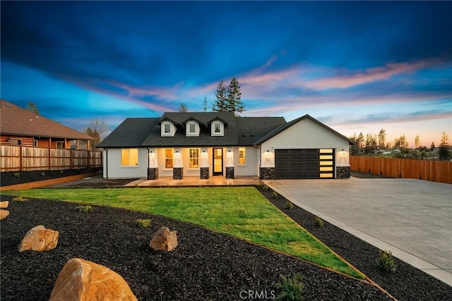 view of front facade with a garage, fence, driveway, stone siding, and stucco siding