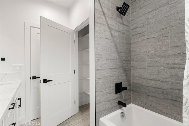 bathroom with washtub / shower combination and vanity