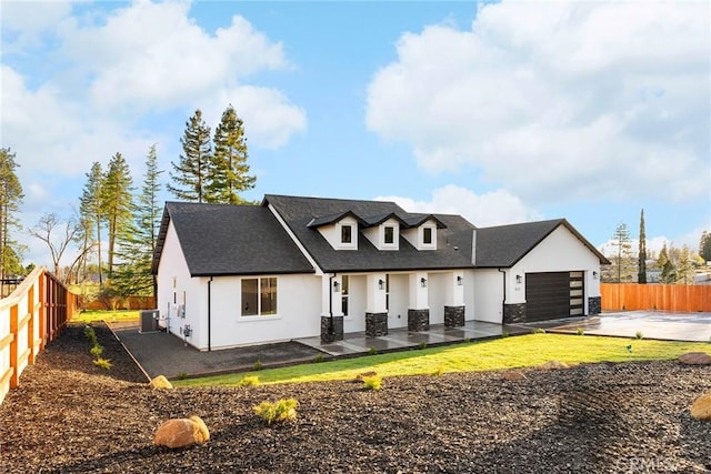 view of front of home with driveway, fence, cooling unit, and stucco siding