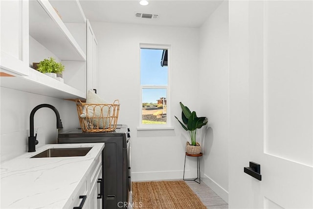 clothes washing area featuring recessed lighting, visible vents, baseboards, cabinet space, and washing machine and clothes dryer