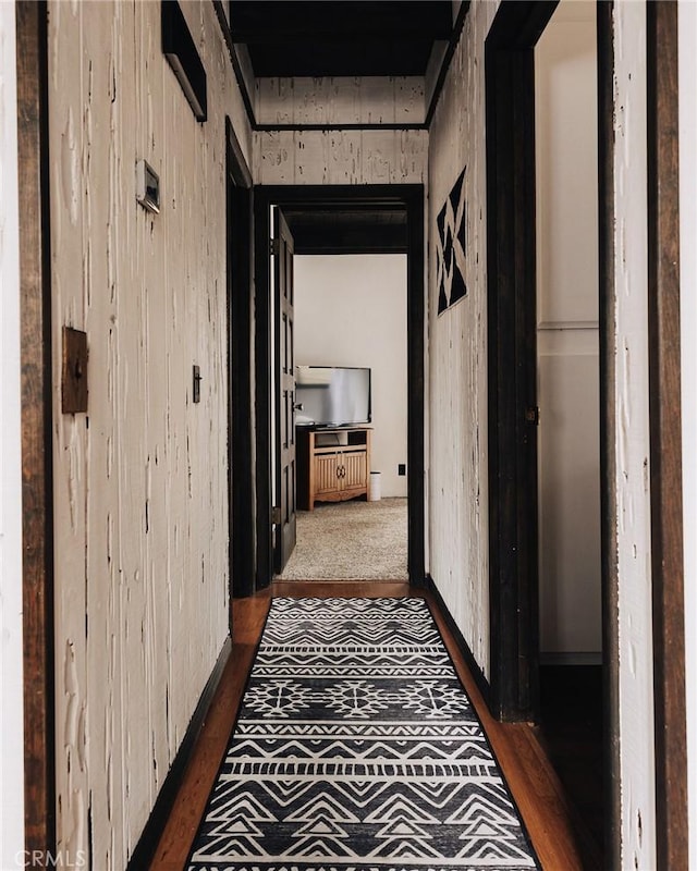 hallway featuring wooden walls