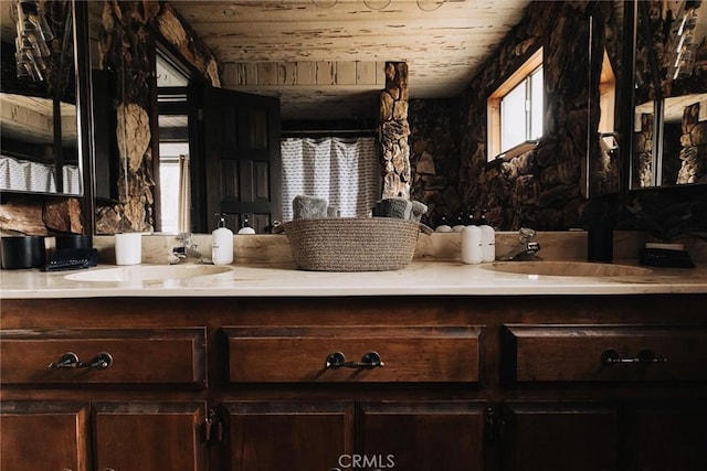 full bathroom with double vanity, wood ceiling, and a sink