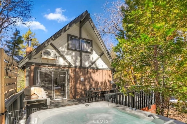 rear view of house with a hot tub