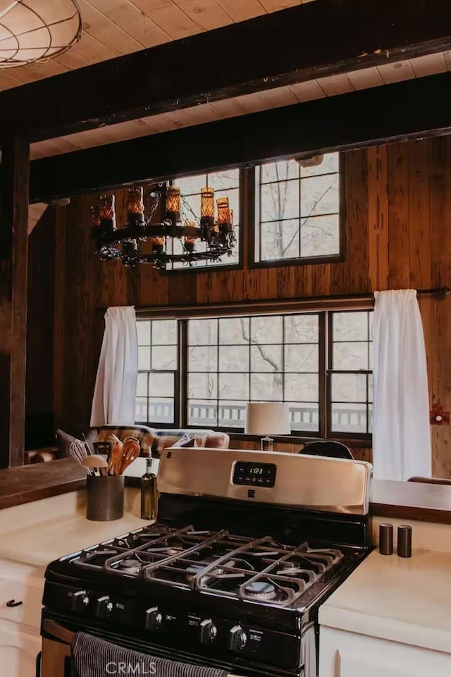 kitchen with wooden ceiling, gas range, and beam ceiling