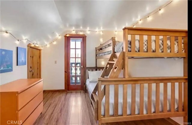 interior space featuring lofted ceiling, rail lighting, and wood finished floors