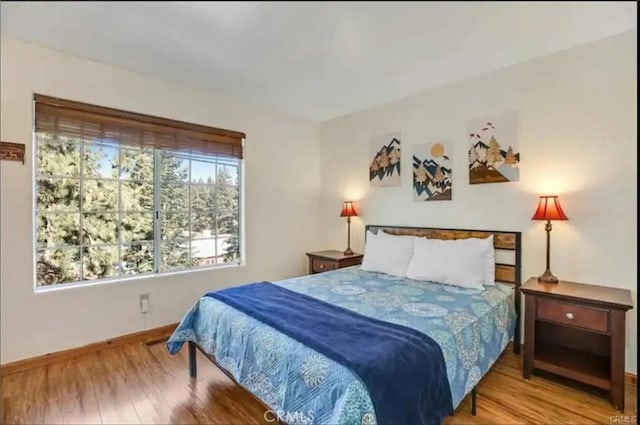 bedroom featuring baseboards and wood finished floors