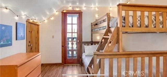 bedroom with vaulted ceiling and wood finished floors