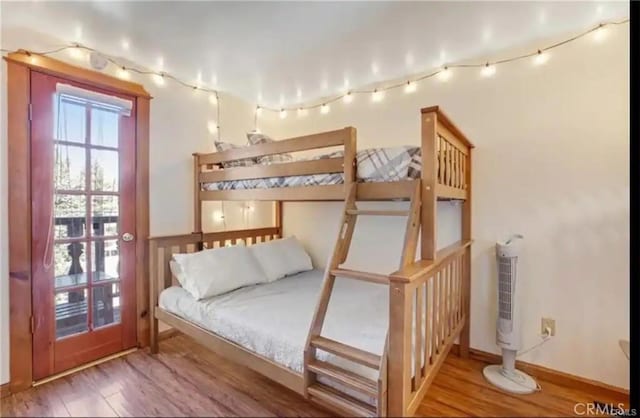 bedroom with wood finished floors and baseboards