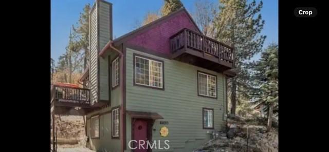 back of property featuring a chimney and a balcony