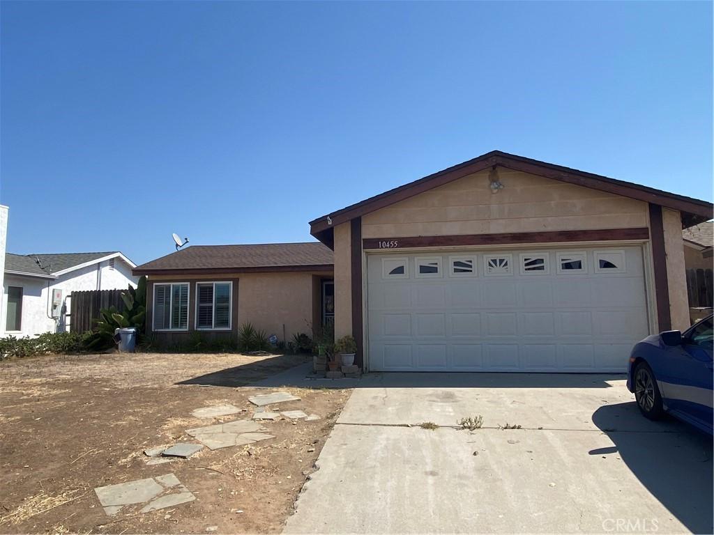 ranch-style home with a garage, concrete driveway, and stucco siding