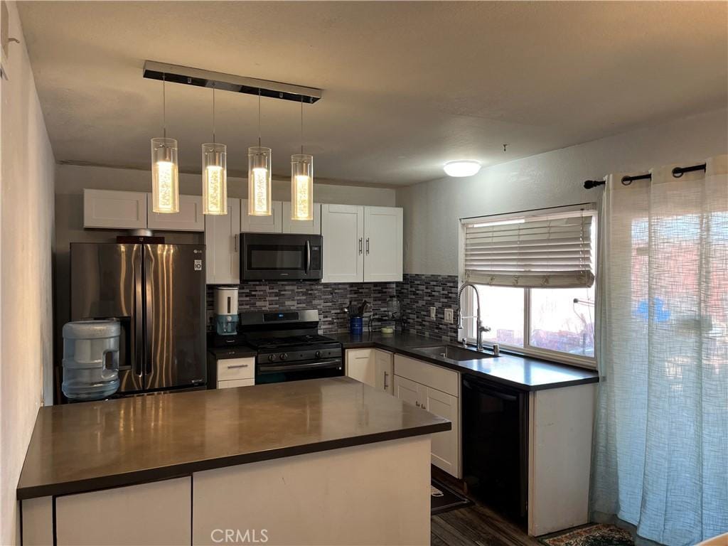 kitchen featuring a sink, white cabinets, decorative backsplash, black appliances, and dark countertops