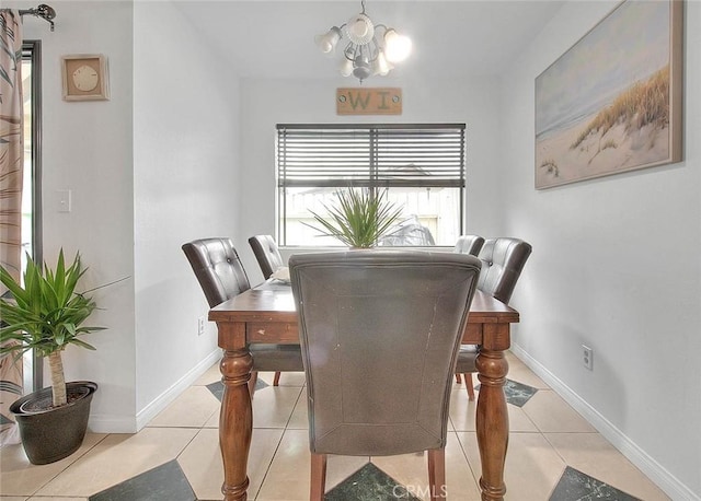 dining area with a chandelier, light tile patterned flooring, and baseboards