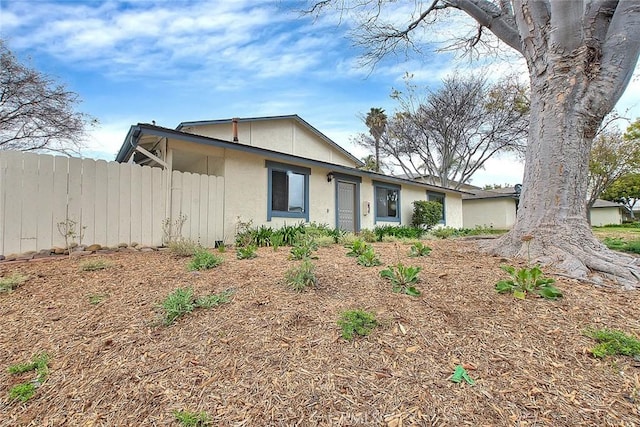 view of front of house featuring fence and stucco siding