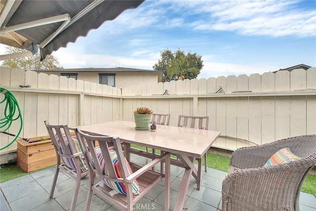 view of patio with outdoor dining space and fence