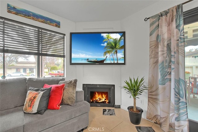 tiled living room featuring a lit fireplace