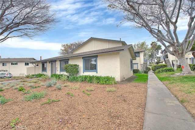 view of property exterior with stairway and stucco siding