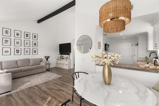 interior space featuring beam ceiling, dark wood-type flooring, high vaulted ceiling, recessed lighting, and a chandelier