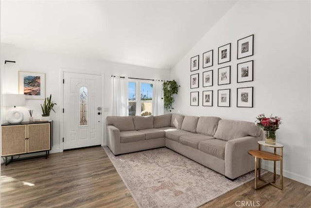 living room with high vaulted ceiling, baseboards, and wood finished floors