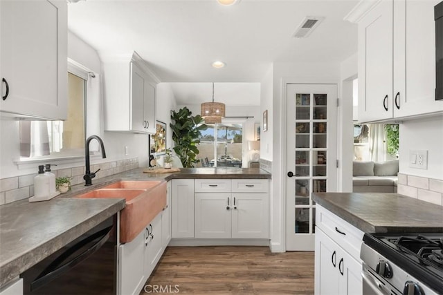 kitchen with visible vents, a sink, black dishwasher, white cabinets, and stainless steel gas range