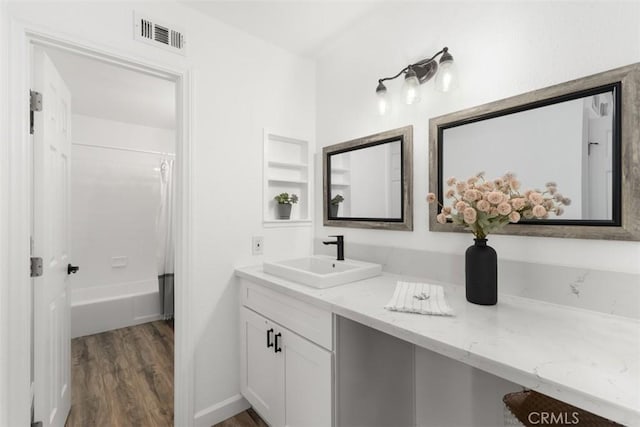 full bath with visible vents, wood finished floors, vanity, and shower / bath combination with curtain