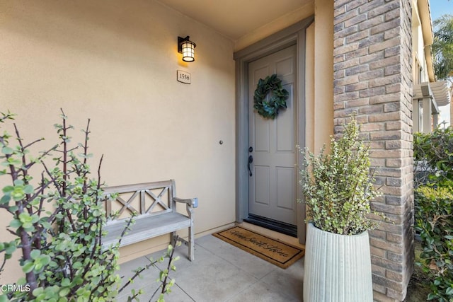 property entrance with brick siding and stucco siding