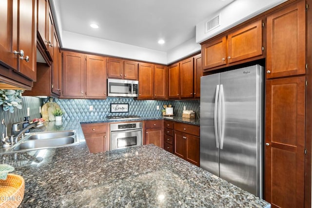 kitchen featuring stainless steel appliances, visible vents, a sink, and decorative backsplash