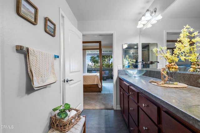 ensuite bathroom featuring tile patterned floors, connected bathroom, and vanity