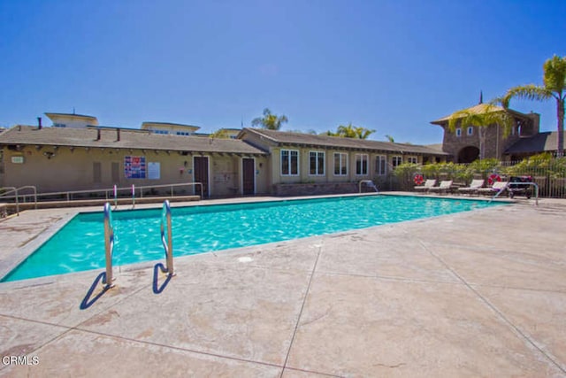 community pool featuring a patio area and fence