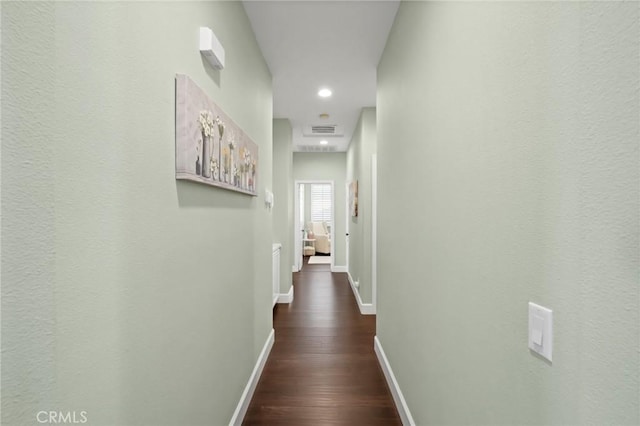 hallway featuring recessed lighting, visible vents, baseboards, and dark wood-type flooring