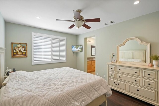 bedroom with visible vents, dark wood finished floors, recessed lighting, ensuite bath, and a ceiling fan