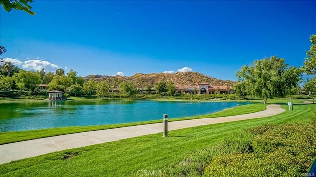 view of community with a water and mountain view and a lawn