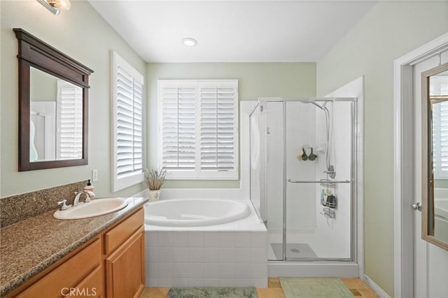 bathroom with plenty of natural light, a shower stall, vanity, and a garden tub