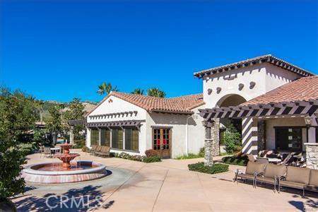 rear view of property featuring a tiled roof, a pergola, and a patio