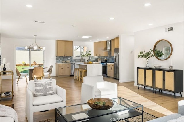 living room with an inviting chandelier, recessed lighting, visible vents, and light wood-type flooring