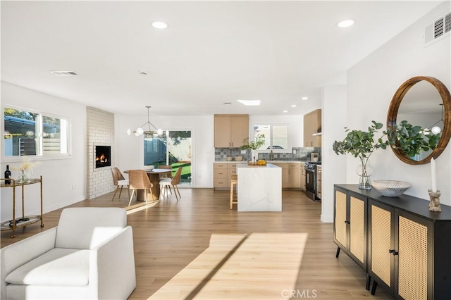 living area with visible vents, a healthy amount of sunlight, and light wood-style floors