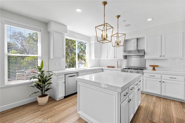 106 Via Sabinas, San Clemente, CA 92673 - kitchen with wall chimney exhaust hood, dishwasher, light wood finished floors, a chandelier, and stove