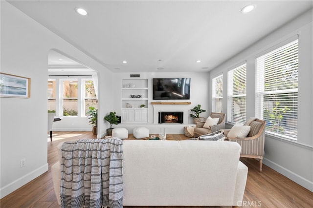 106 Via Sabinas, San Clemente, CA 92673 - living room with baseboards, recessed lighting, a warm lit fireplace, wood finished floors, and built in features